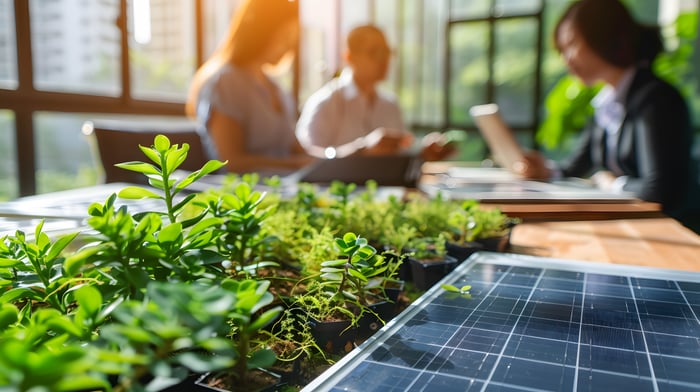 Mitarbeiter im Hintergrund, im Forderung grüne Pflanzen und ein Solarpanel