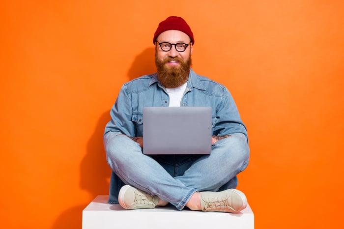 Soloselbstständiger im Schneidersitz mit Laptop